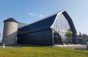 exterior of converted barn with new roof and lamarche electric sign on glass