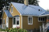 exterior of small yellow home with new metal roof