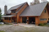 large wooden cottage with two door garage and metal roofing