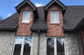 charcoal shingles on roof of home with four windows