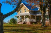 platinum shingle on exterior of home with red leaves on the grass in front of it